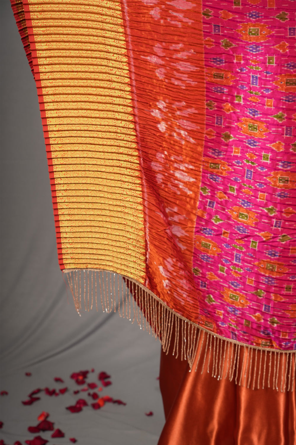 Pink and rust pleated half and half satin saree with patola digital print.