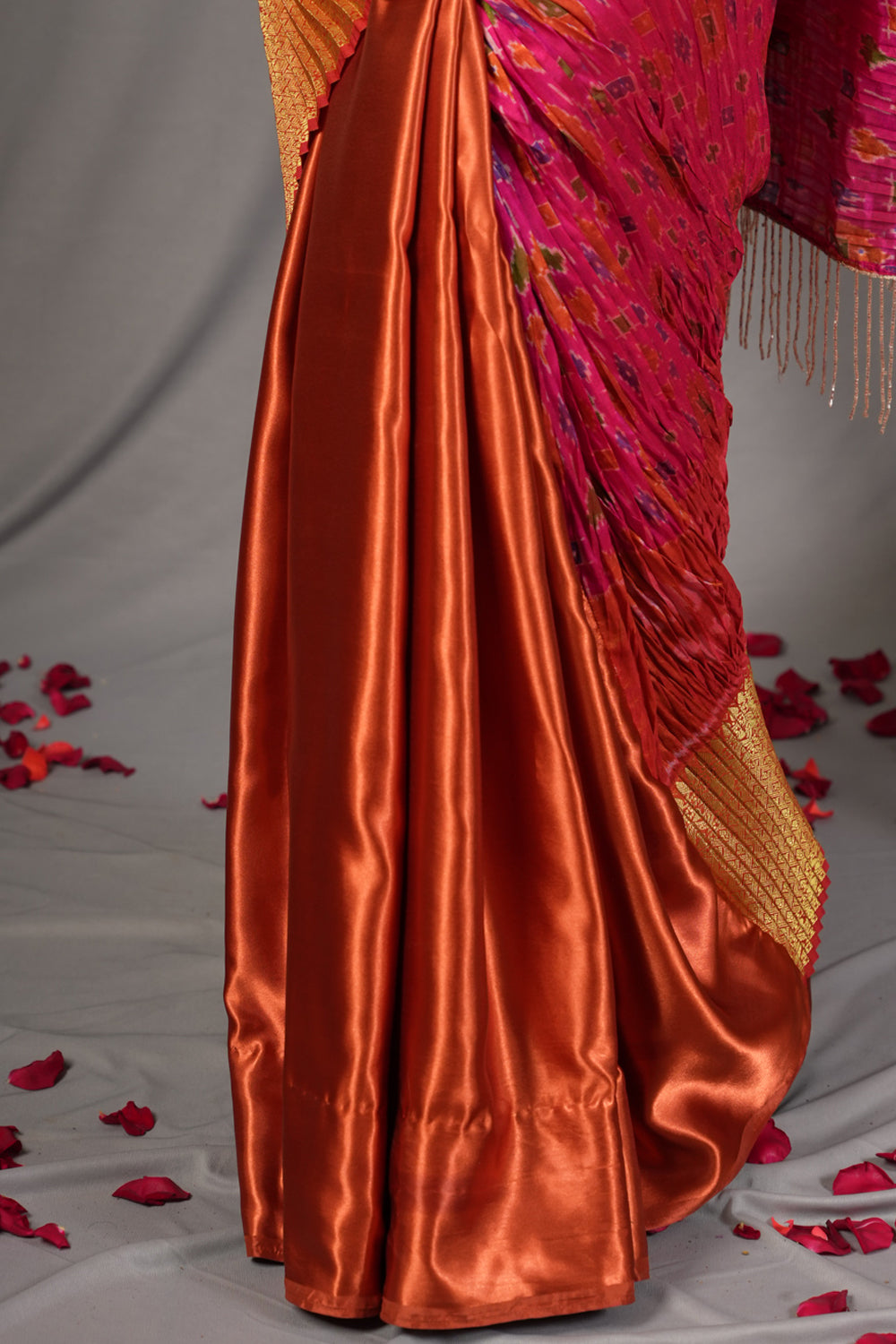 Pink and rust pleated half and half satin saree with patola digital print.