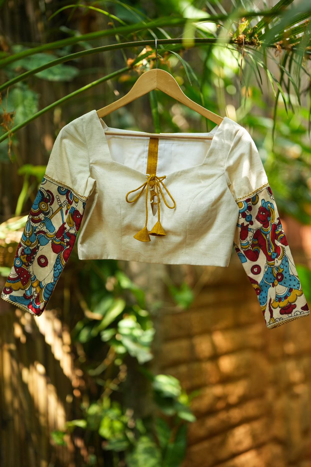 Porcelain white square neck blouse with handpainted kalamkari sleeve detailing.