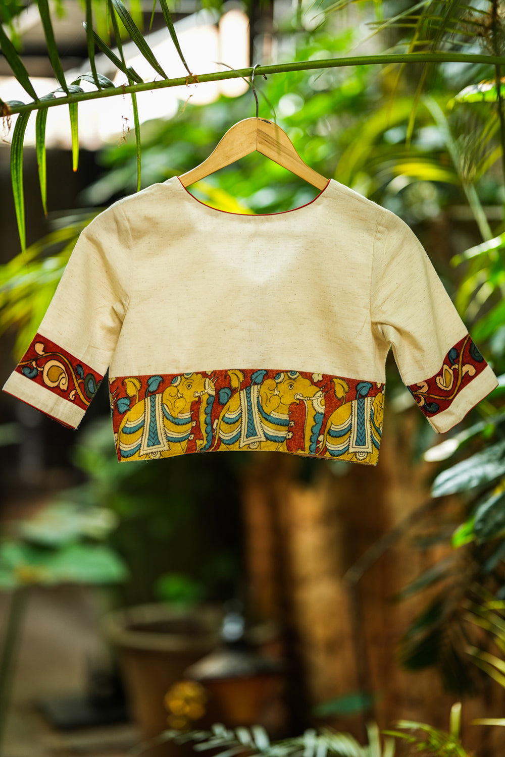 Daisy white V neck blouse with handpainted kalamkari border.