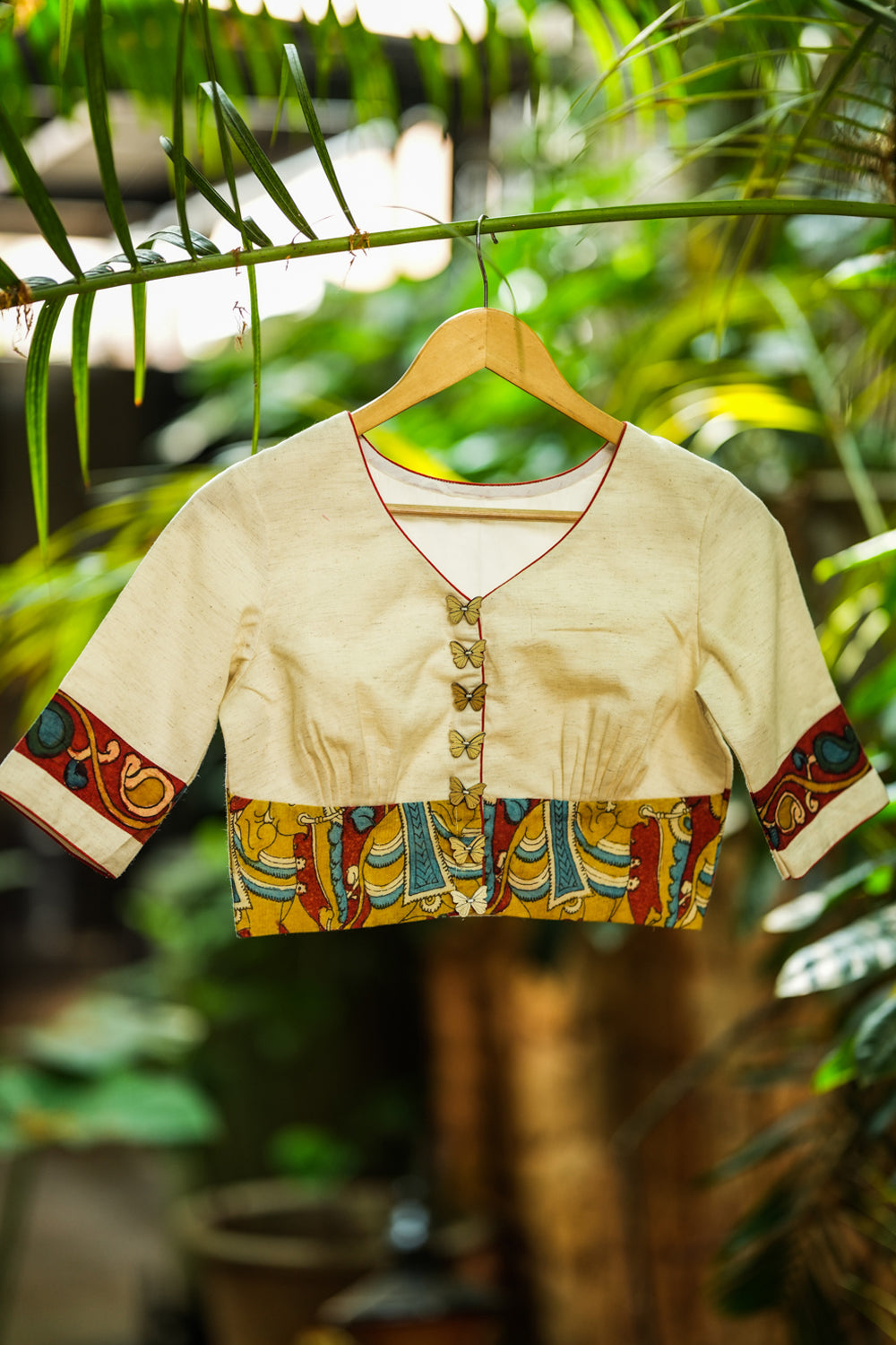 Daisy white V neck blouse with handpainted kalamkari border.