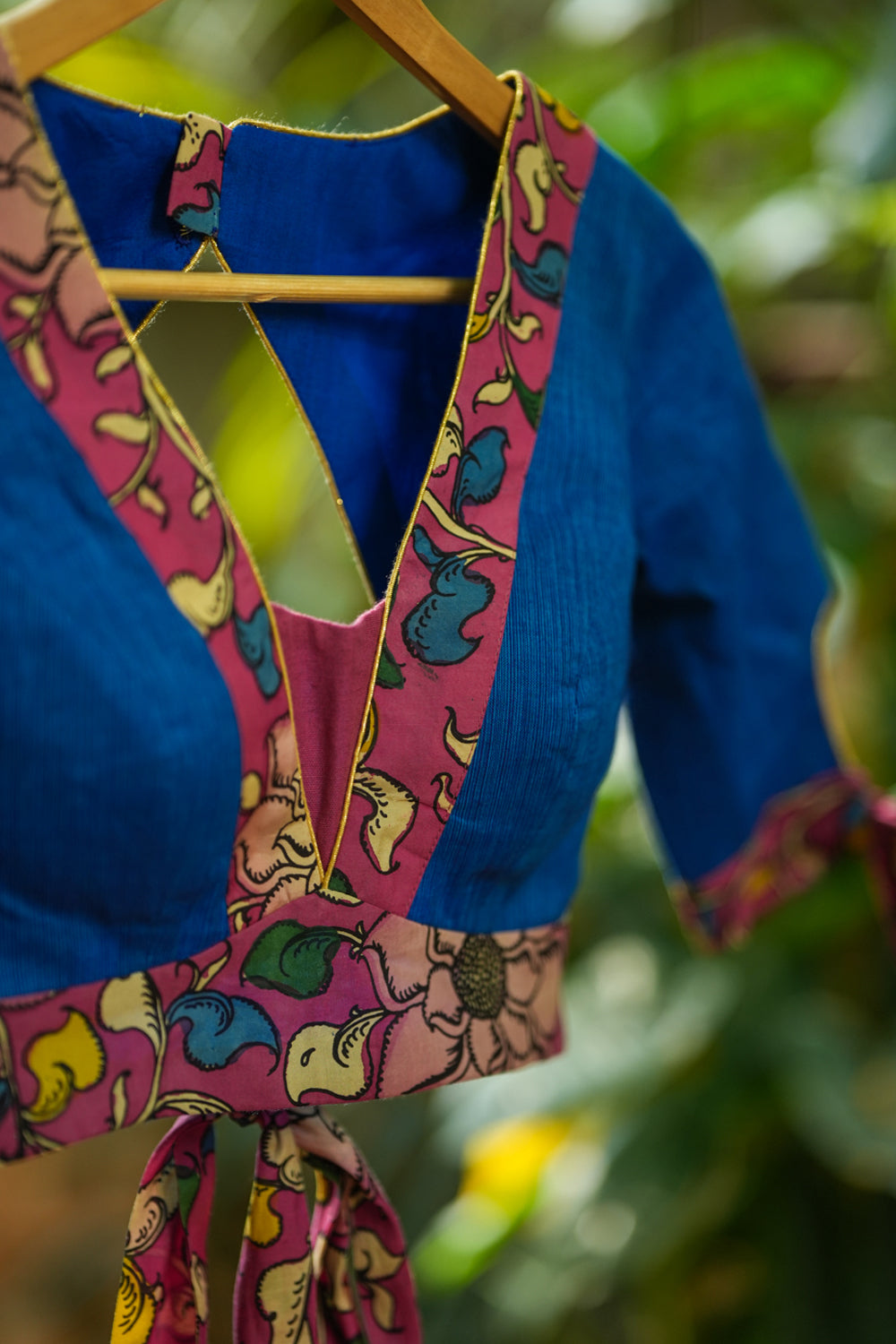 Ocean blue handloom V neck blouse with rose pink handpainted kalamkari border detailing.