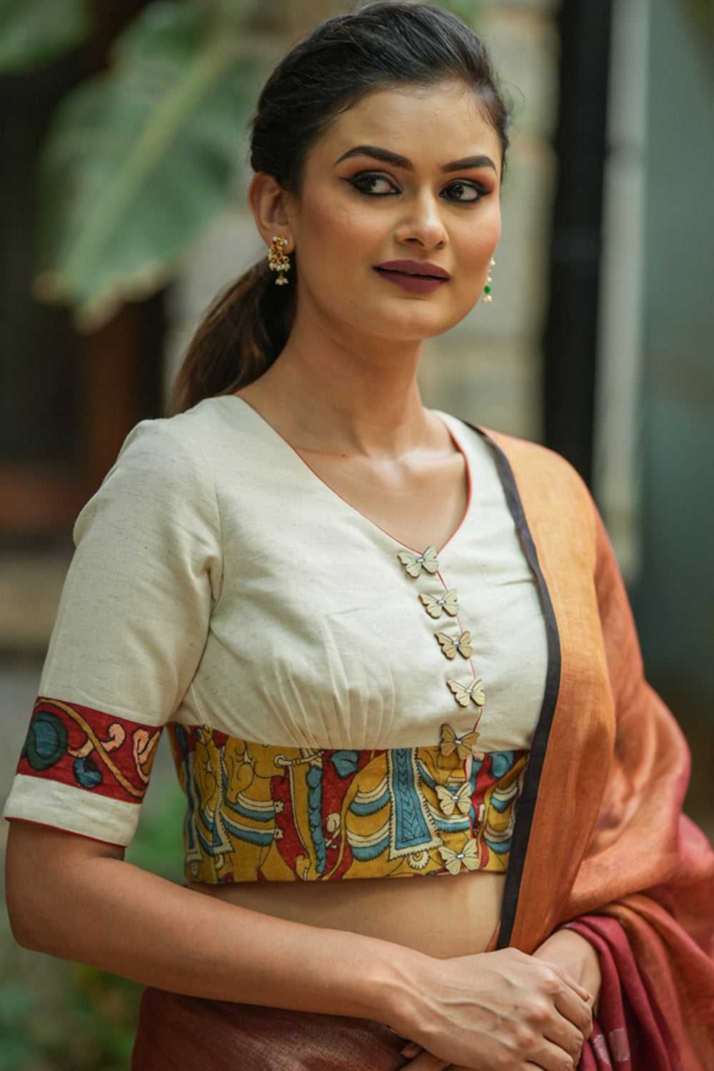 Daisy white V neck blouse with handpainted kalamkari border.