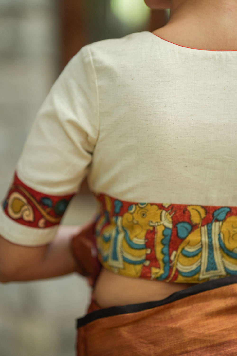 Daisy white V neck blouse with handpainted kalamkari border.
