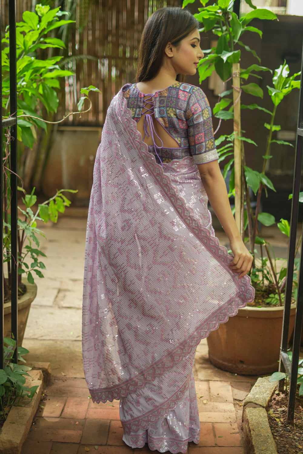 Lavender georgette sequin saree with scalloped edging.