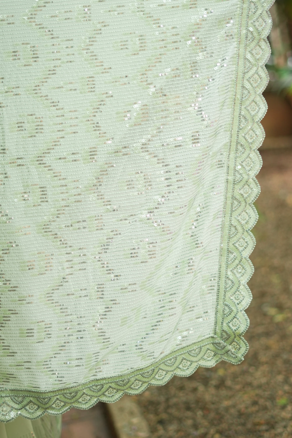 Pista green georgette sequin saree with scalloped edging