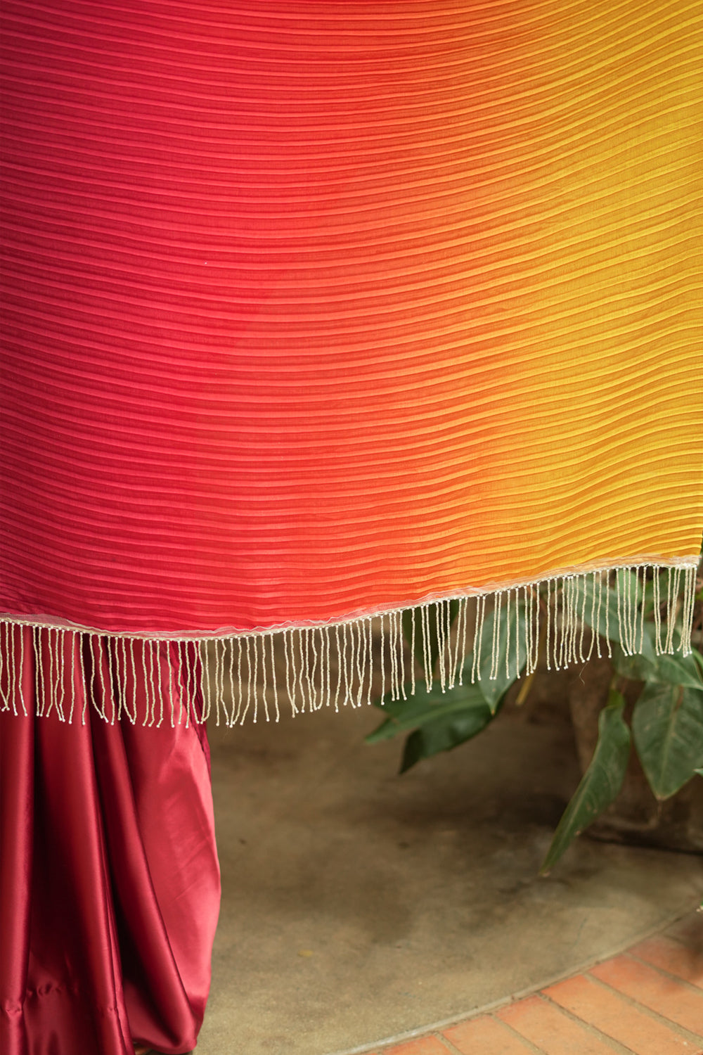 Pleated and satin half and half ombre shaded maroon and mustard saree.