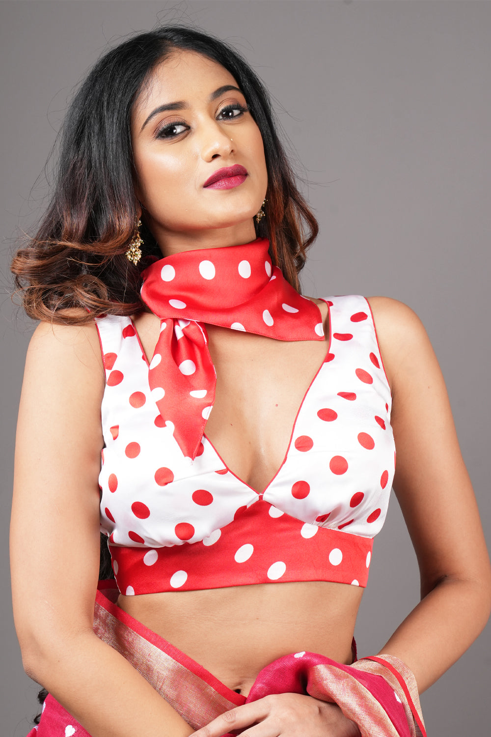 Retro red and white polka dot V neck satin sleeveless blouse with contrasting red scarf.