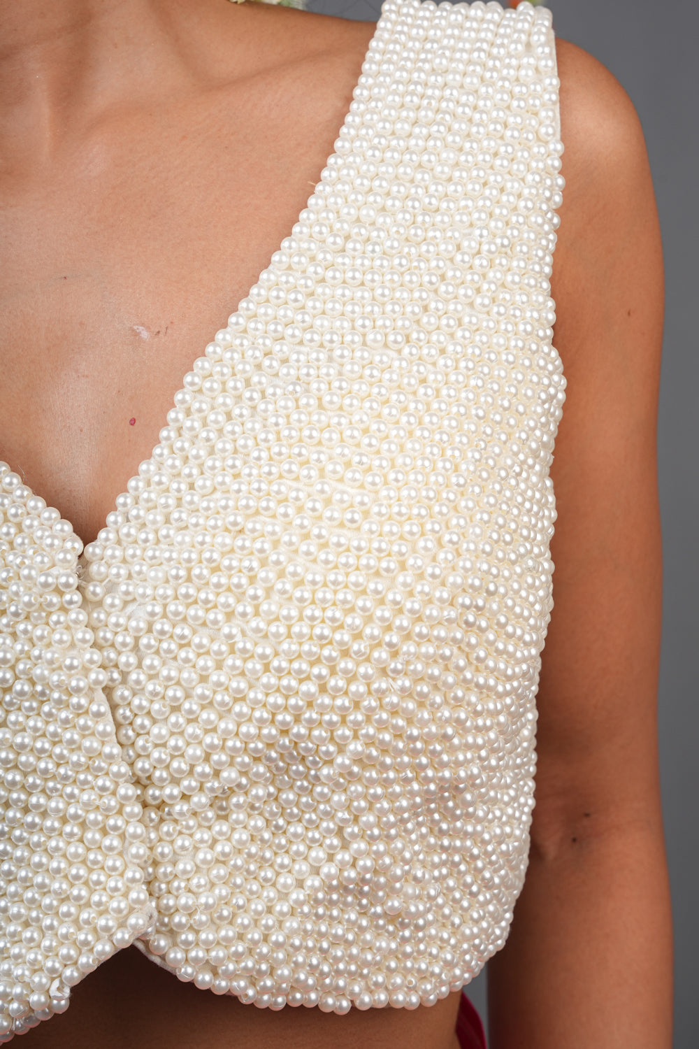 Embedded beads sleeveless blouse with multiple beads strands in back.