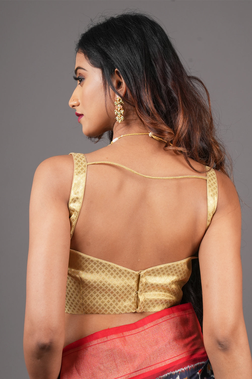 Gold brocade sweetheart neck sleeveless blouse with cutout at waist.