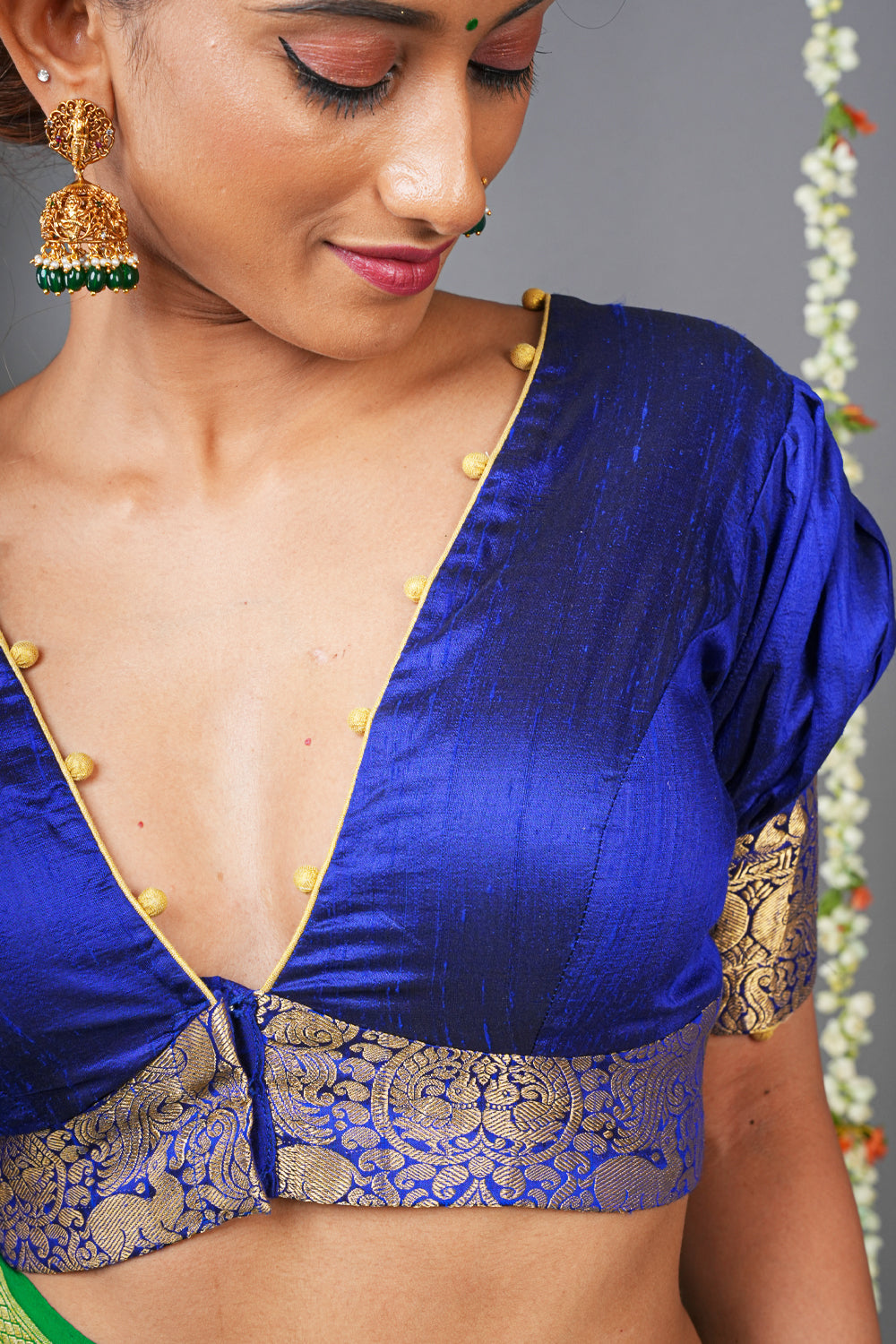 Blue silk V neck blouse with  potli buttons detailing and brocade border.