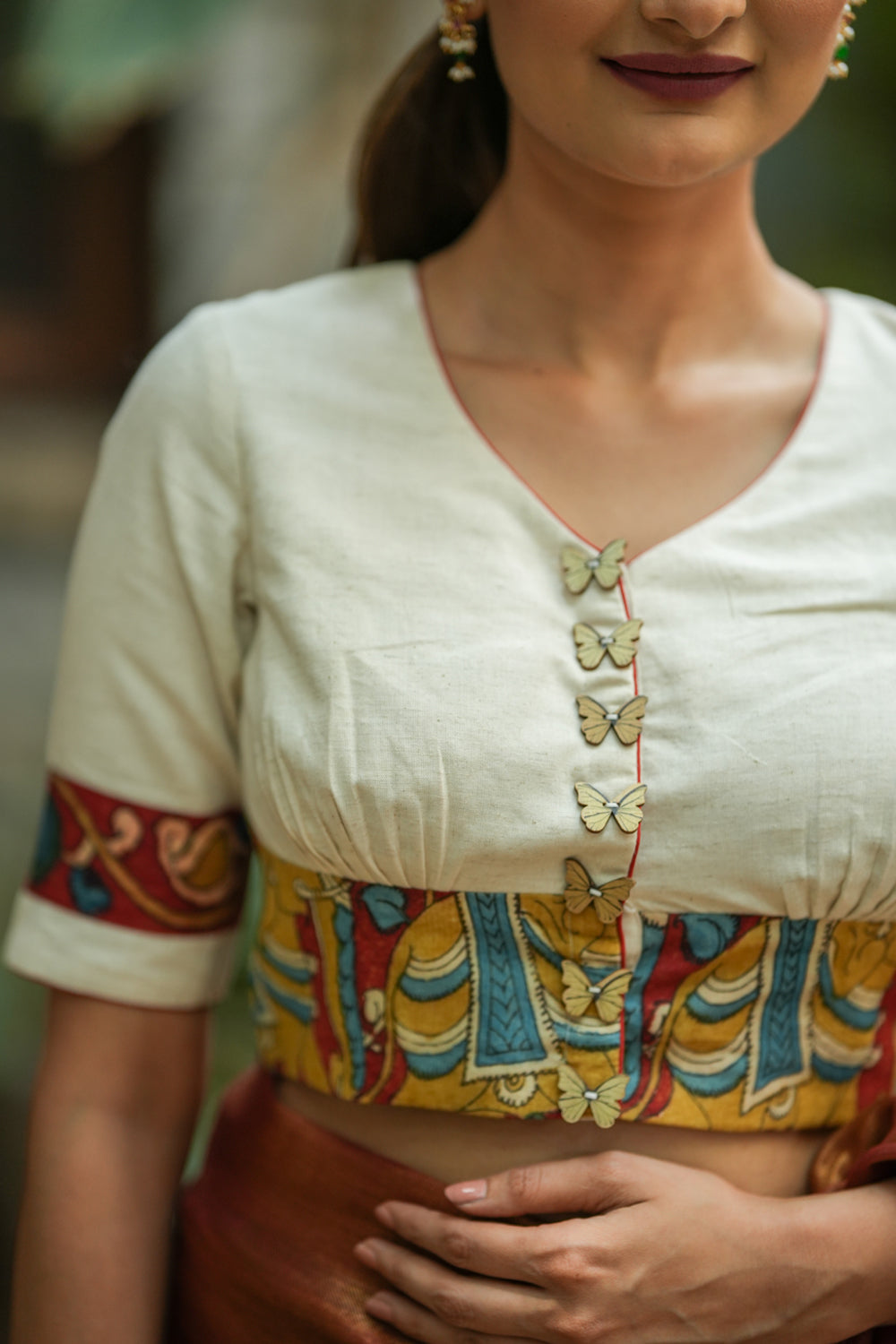 Daisy white V neck blouse with handpainted kalamkari border.