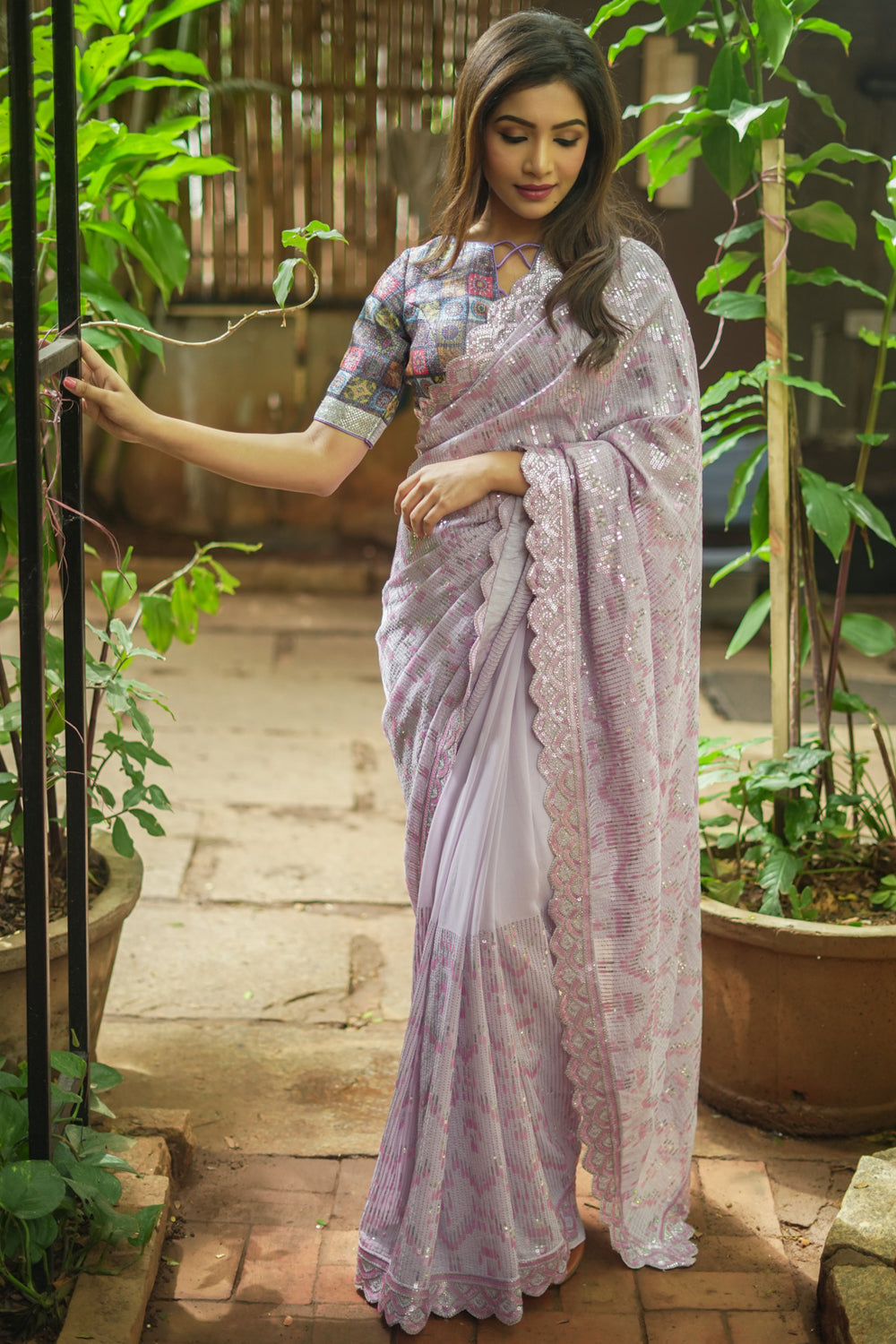 Lavender georgette sequin saree with scalloped edging.
