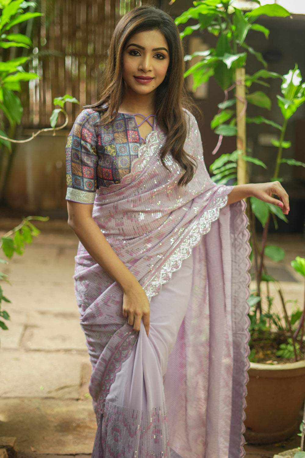 Lavender georgette sequin saree with scalloped edging.