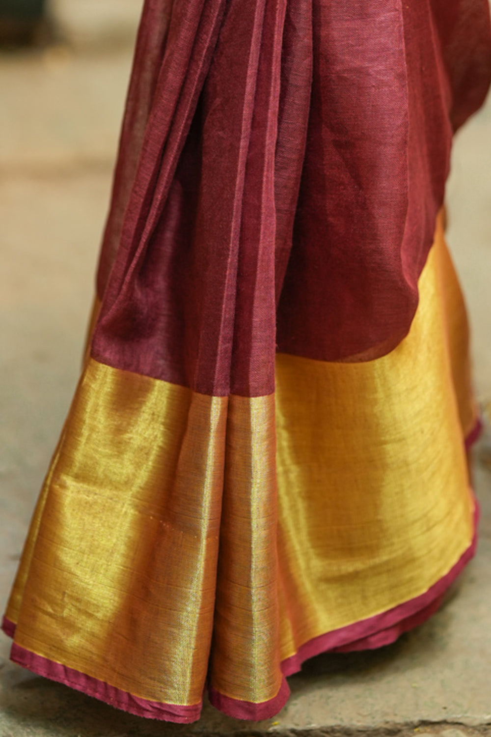 Maroon linen saree with wide antique gold border