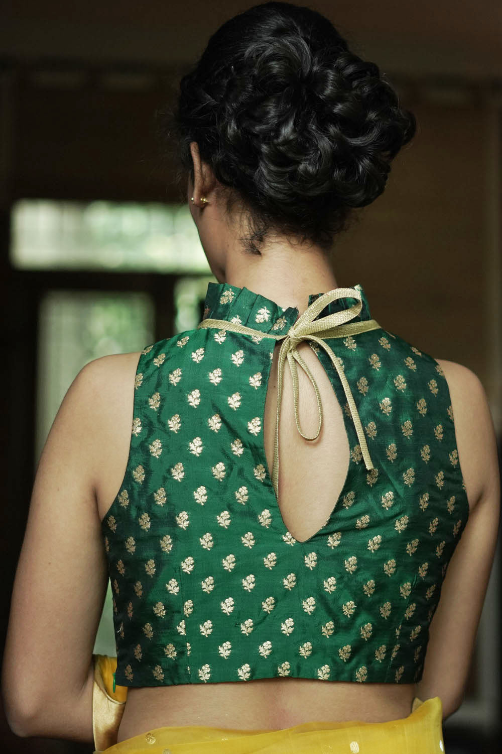 Bottle green banarasi brocade sleeveless blouse with ruffles on neck