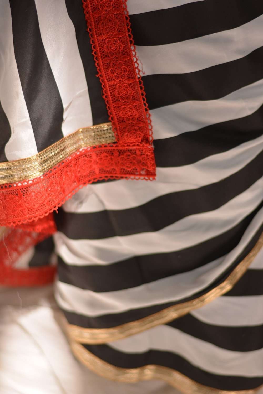 Black and white striped crepe saree with gold and red lace border - House of Blouse