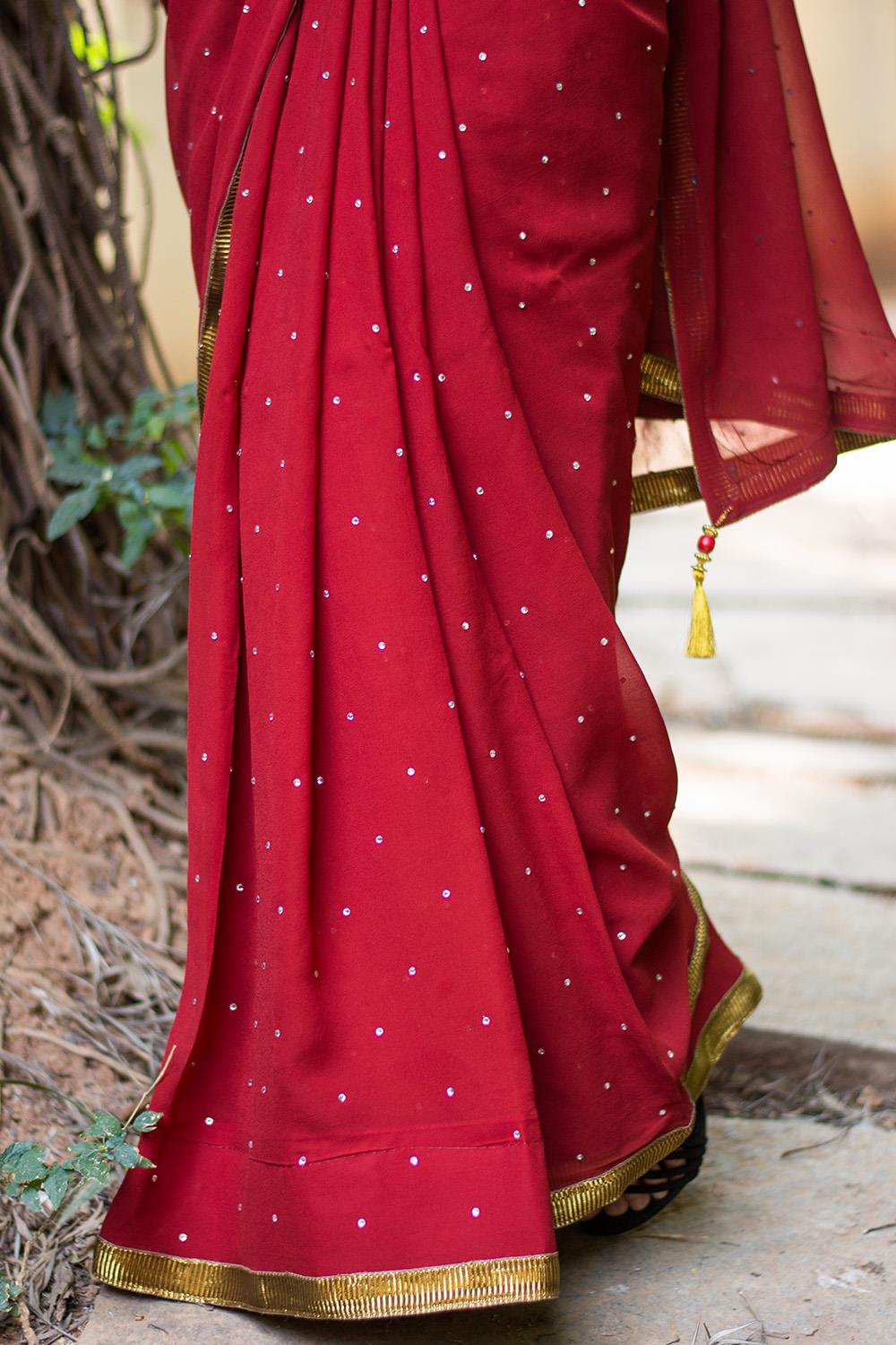 Deep red georgette saree with stone work and antique crushed gota border