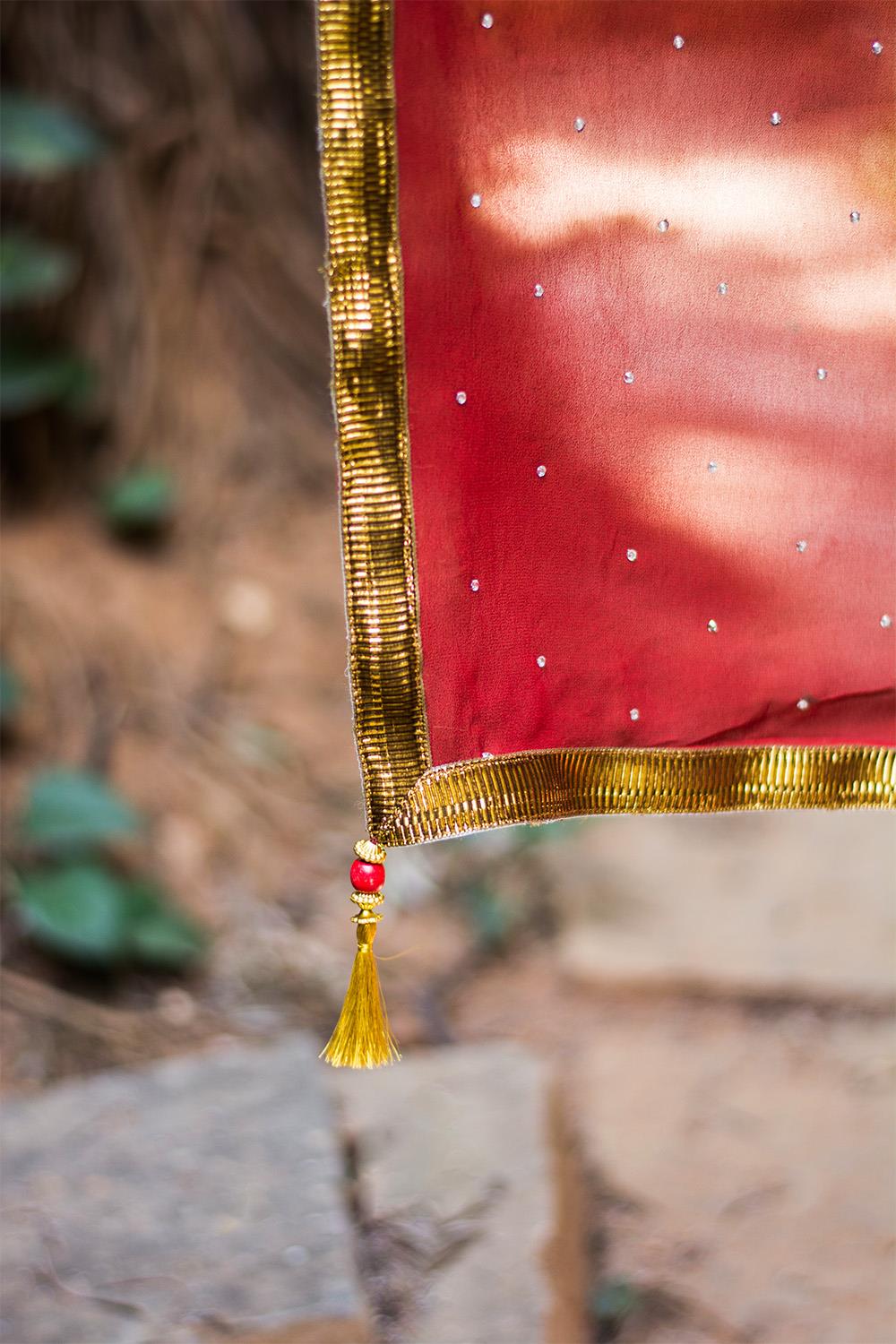 Deep red georgette saree with stone work and antique crushed gota border